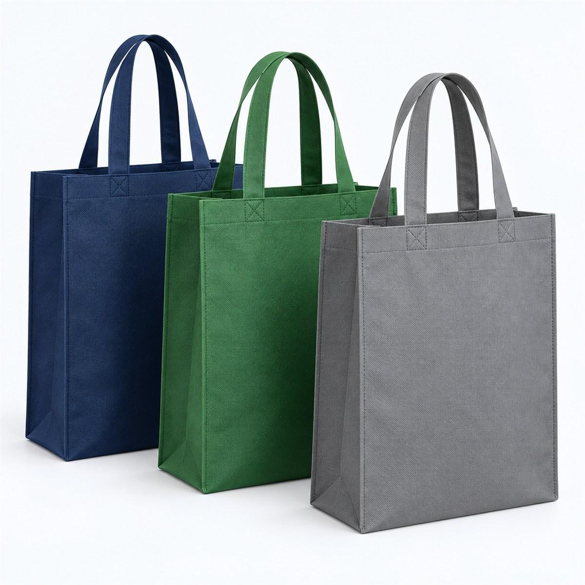 Tiga contoh goodie bag spunbond jahit dalam warna biru muda, merah, dan hijau